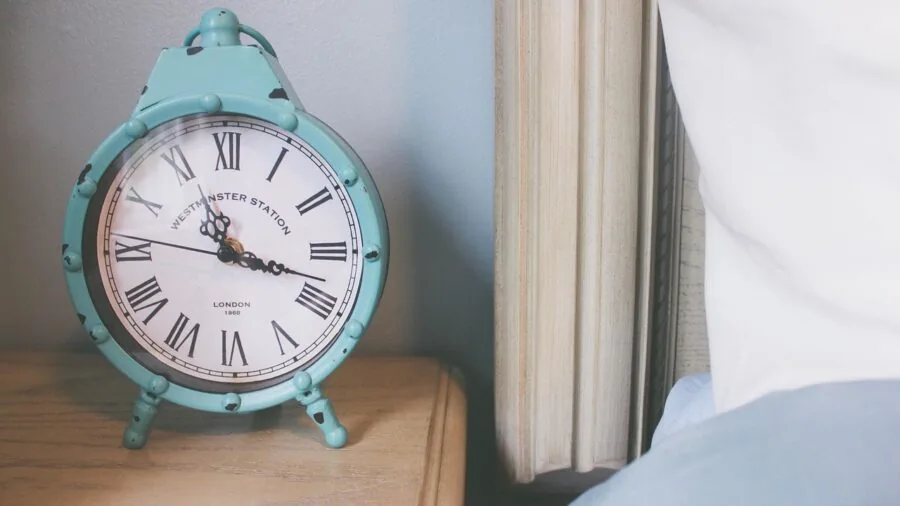 Modern nightstand with watch and home accessories in bright bedroom setting