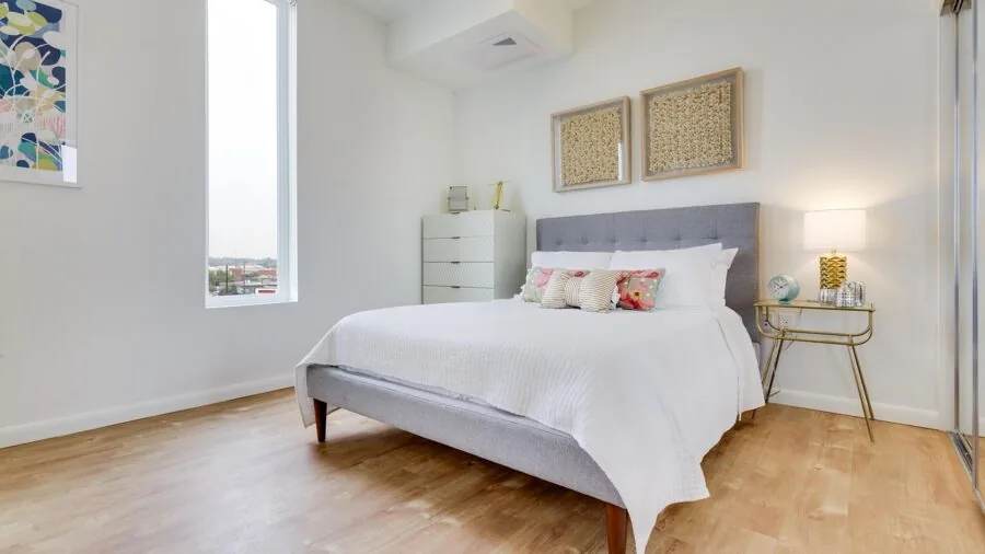 Modern wooden dresser in bright nursery room with changing pad on top, showcasing furniture convertibility