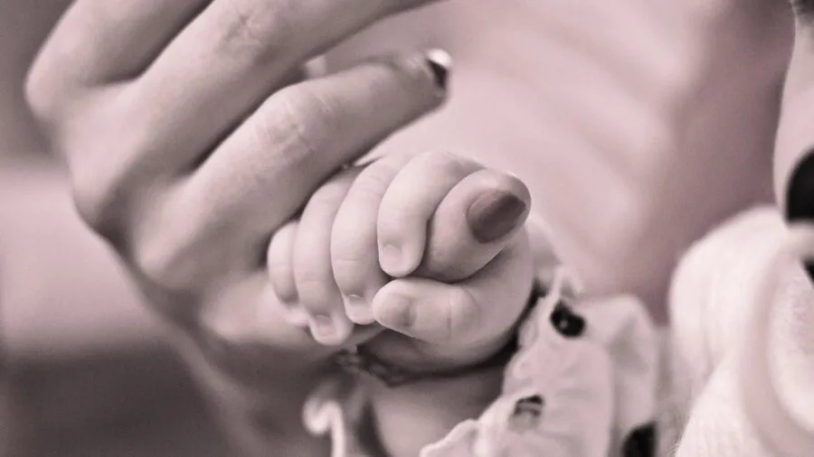 Mother holding newborn baby in arms during intimate bonding moment