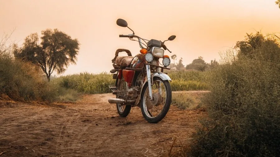 Motorcycle parked inside garage with protective cover against dust and tools in background