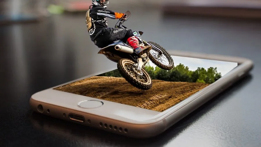 Motorcyclist on bike checking phone mounted on handlebars during ride