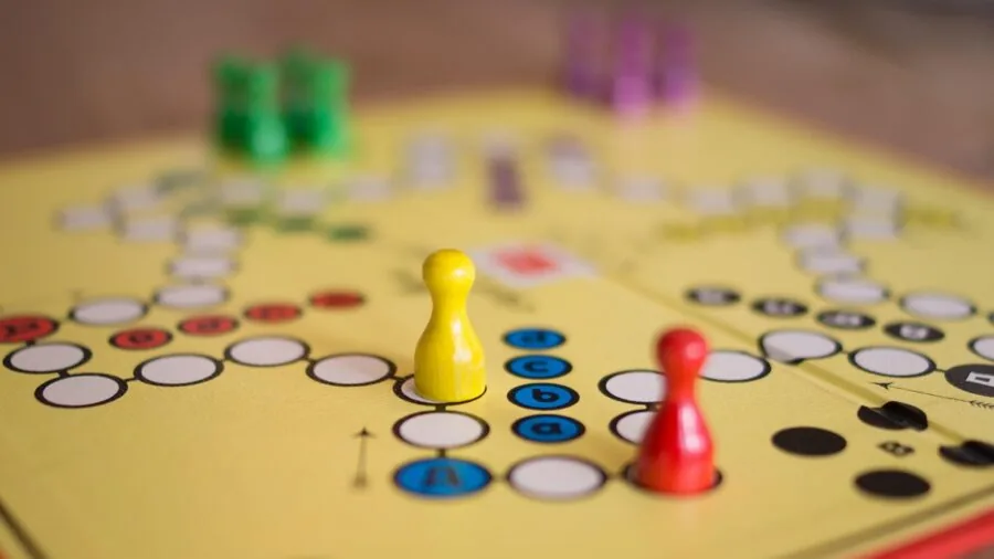 Multi-generational family engaged in a board game night, showing fun interaction and laughter around a table