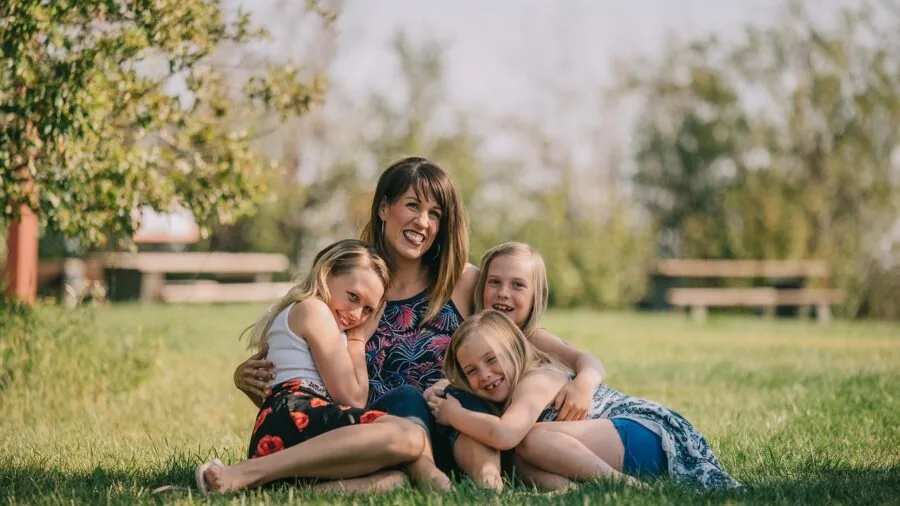 Multi-generational family enjoying outdoor lawn games in backyard during summer afternoon