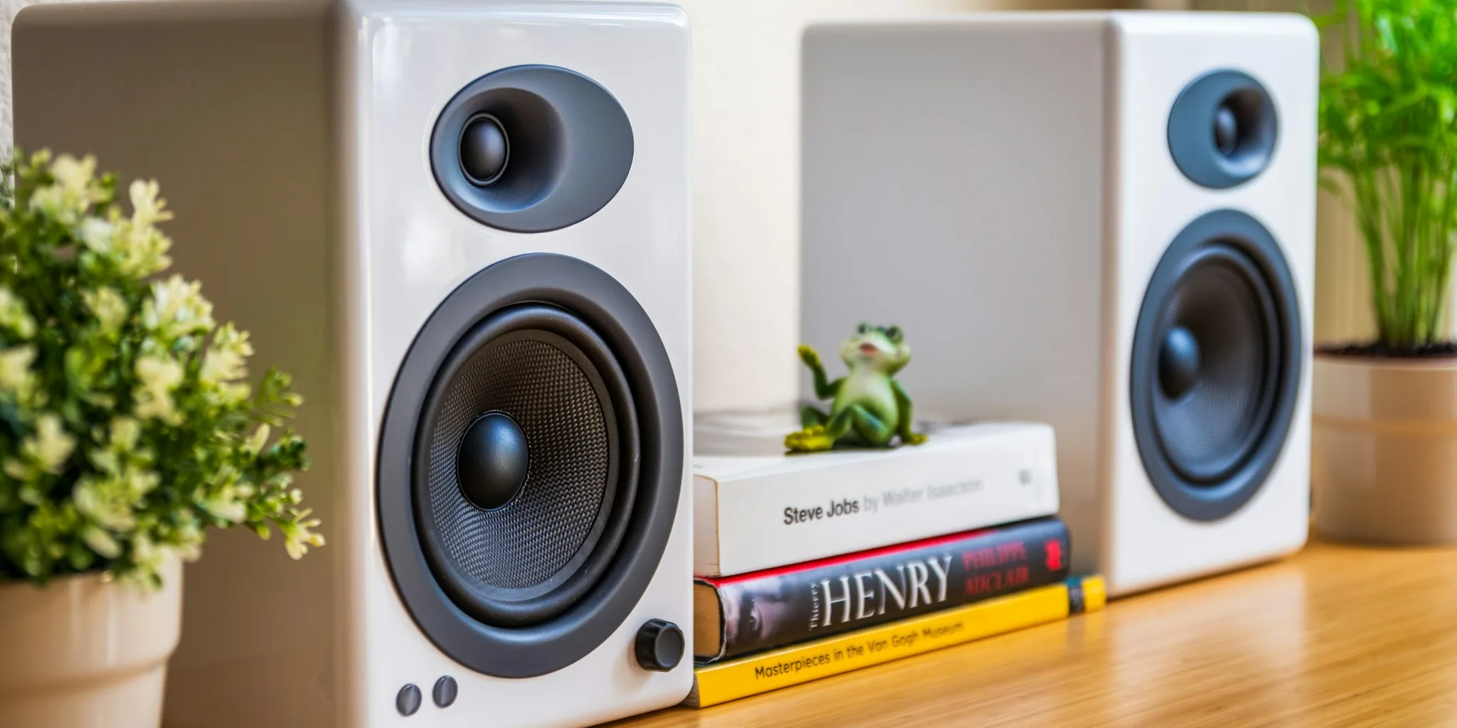 Multiple portable bluetooth speakers displayed on wooden table with natural lighting