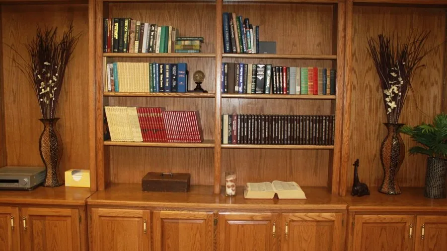 Multiple shelves with organized books and storage in a modern office workspace setup