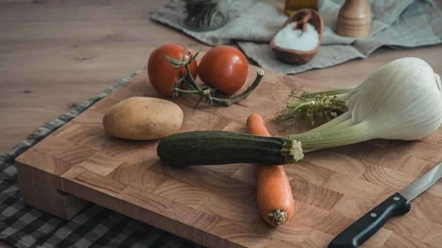Multiple wooden cutting boards arranged on a kitchen counter during food preparation