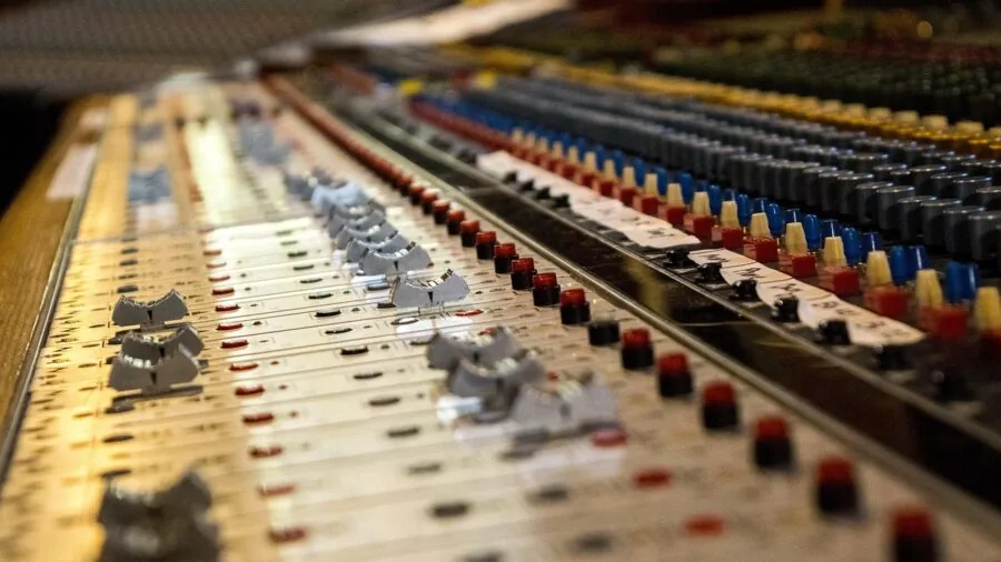 Music producer working in professional studio with mixing equipment and monitors