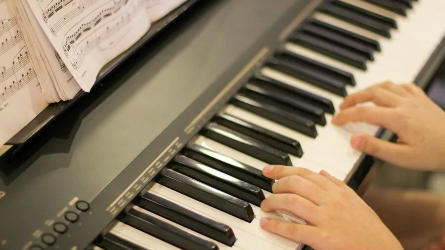 Musician performing on digital piano in recording studio with focused expression