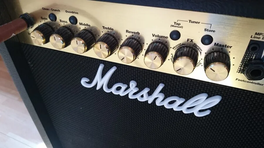 Musician's hands connecting cables on a guitar pedalboard setup during practice session