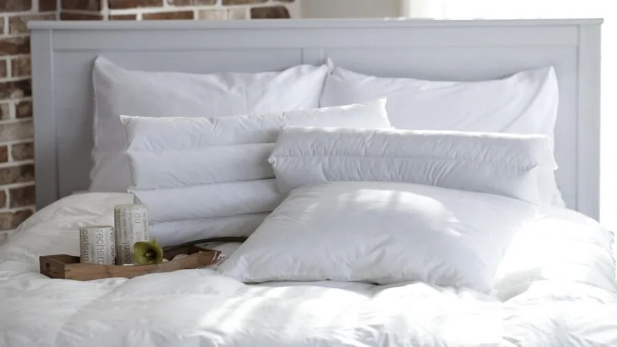 Neatly arranged complete bedding set with pillows and shams on a made bed in a bedroom