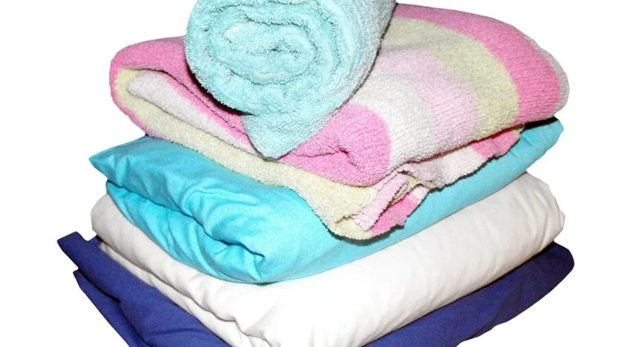 Neatly stacked and folded microfiber towels in various sizes displayed on a shelf