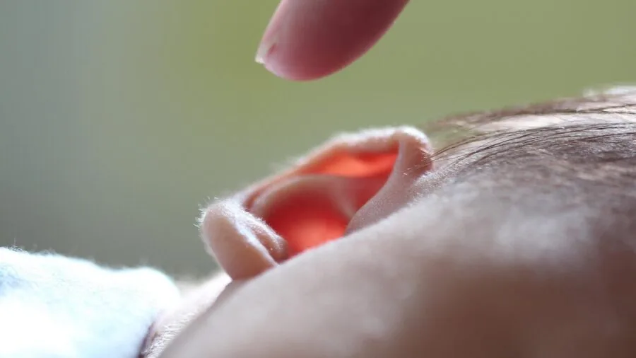 Newborn infant responding to gentle auditory stimulation during developmental play time