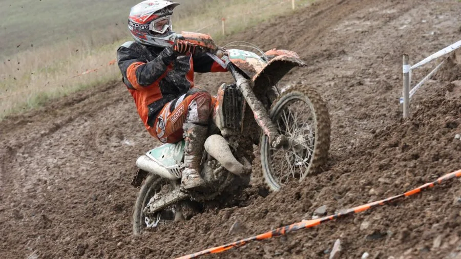 Off-road enthusiast examining ATV gear and equipment outdoors