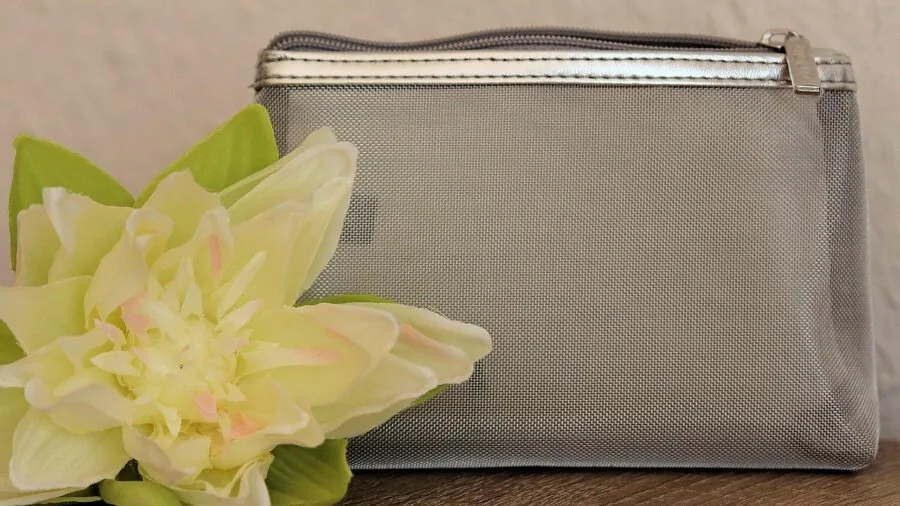 Open makeup bag displaying neatly arranged cosmetics and beauty products in organized compartments