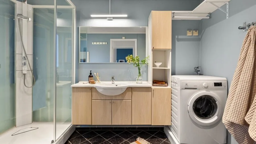 Organized bathroom shelf with neatly folded towels and toiletries displayed on open shelving