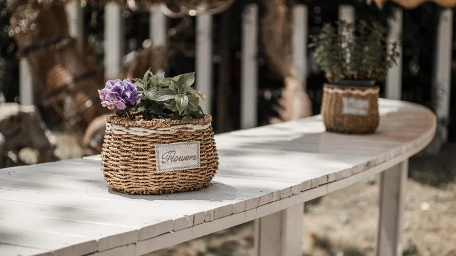Organized craft storage basket containing colorful yarn, hooks, and supplies on wooden table