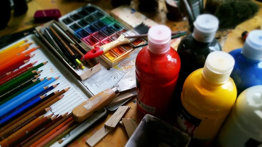 Organized craft supplies and tools arranged on a wooden desk workspace