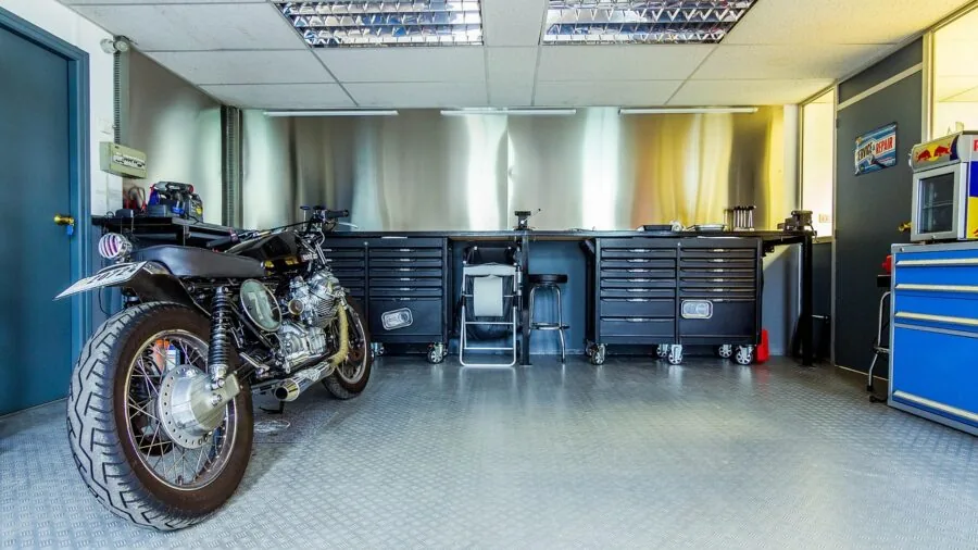 Organized garage workshop with motorcycle parked safely in storage, showing proper maintenance setup and secure storage environment