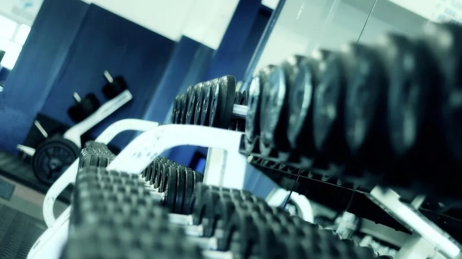 Organized home gym corner with equipment neatly arranged on shelves and floor space