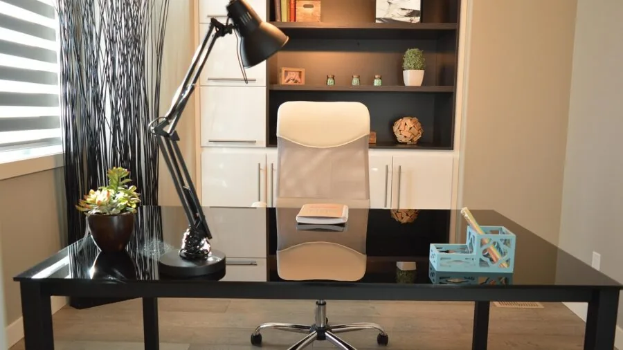Organized home office with shelving units displaying books, plants, and decorative items
