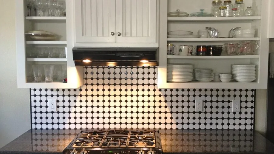 Organized kitchen cabinet interior with neatly arranged dishes and containers on shelves