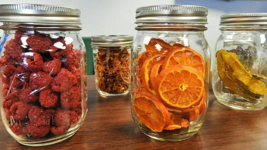 Organized kitchen pantry shelves with various food storage containers and fresh ingredients in natural light