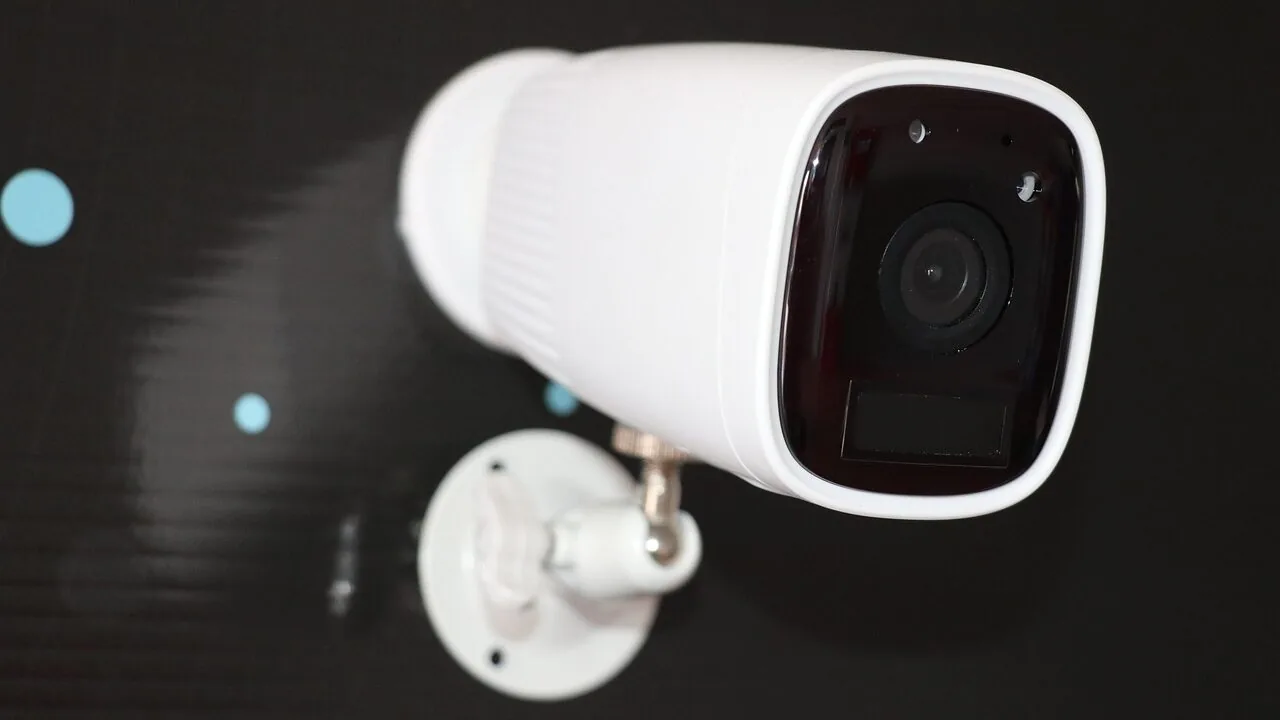 Outdoor security camera mounted on house exterior wall in daylight