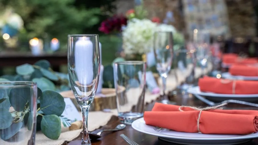 Overhead view of a plated meal on a dinner plate at a formal table setting with utensils and glassware