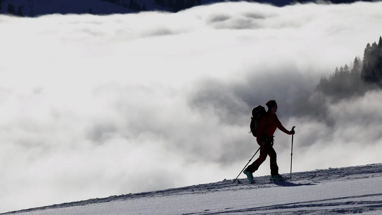 Pair of ski poles stuck in snow on snowy mountain slope