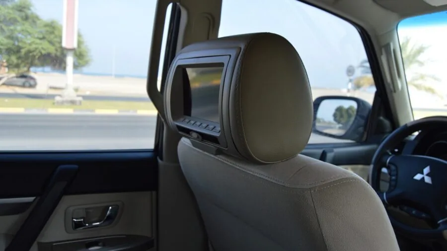 Parent adjusting car seat straps and headrest in vehicle interior during installation