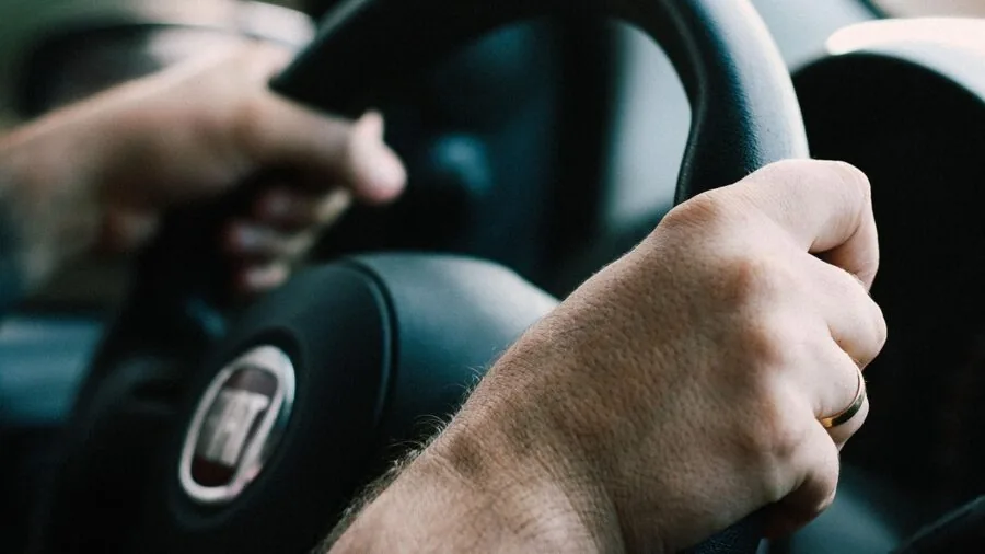 Parent adjusting child safety seat belt positioning in vehicle for proper fit and protection