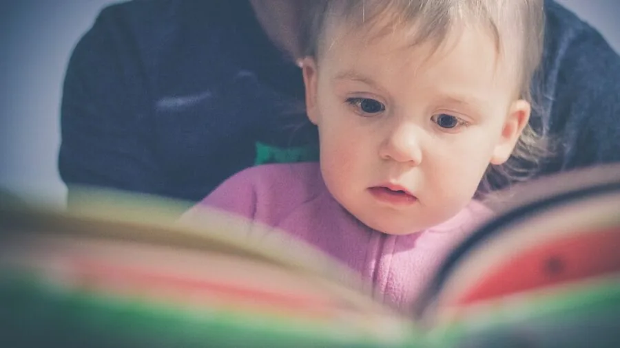 Parent and baby enjoying a soft book together during bonding time, showing real-world reading engagement