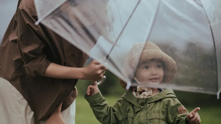 Parent applying sunscreen to baby's skin during outdoor summer activity