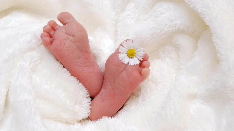 Parent bathing infant with mild cleanser in warm bathroom setting