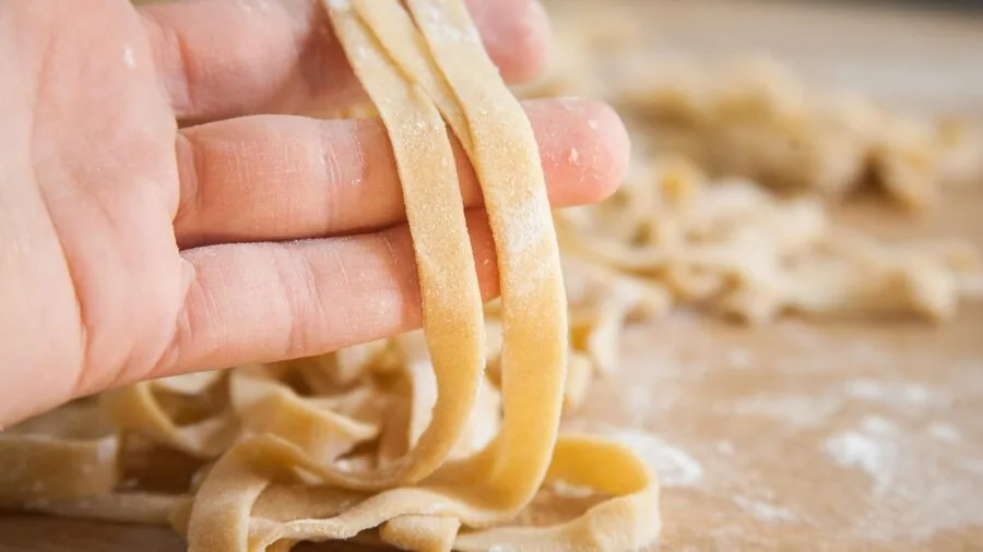 Parent blending fresh vegetables in kitchen while preparing homemade baby food