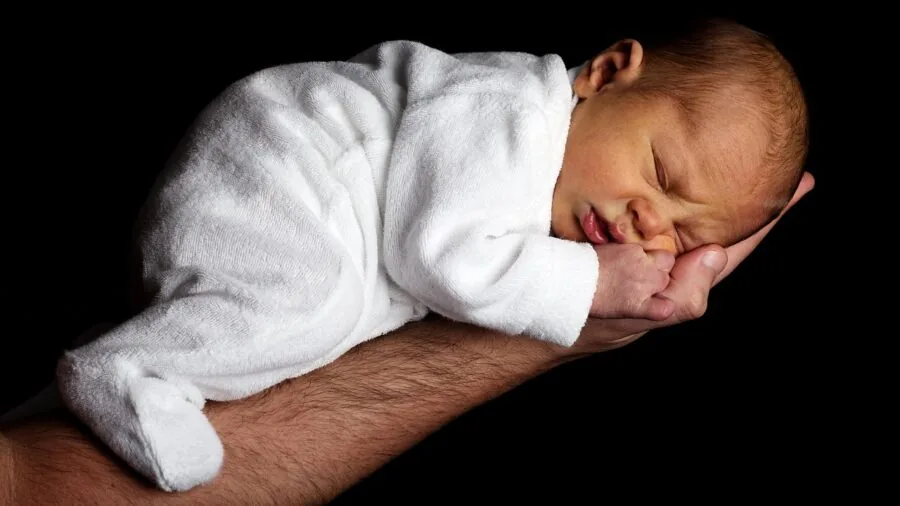 Parent carefully bathing infant with gentle care, focusing on safe skincare routine