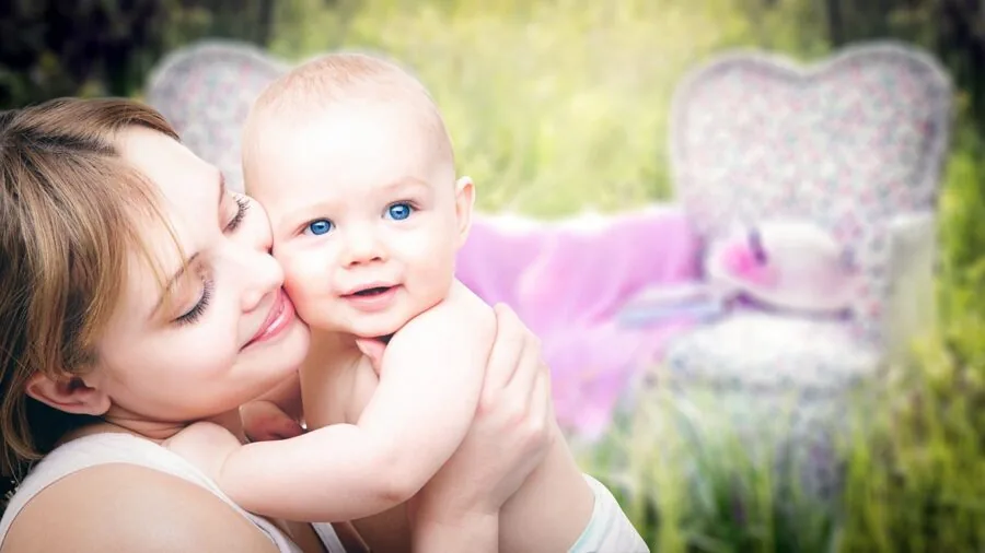 Parent carefully washing and cleaning baby feeding bottles and pump parts at kitchen sink