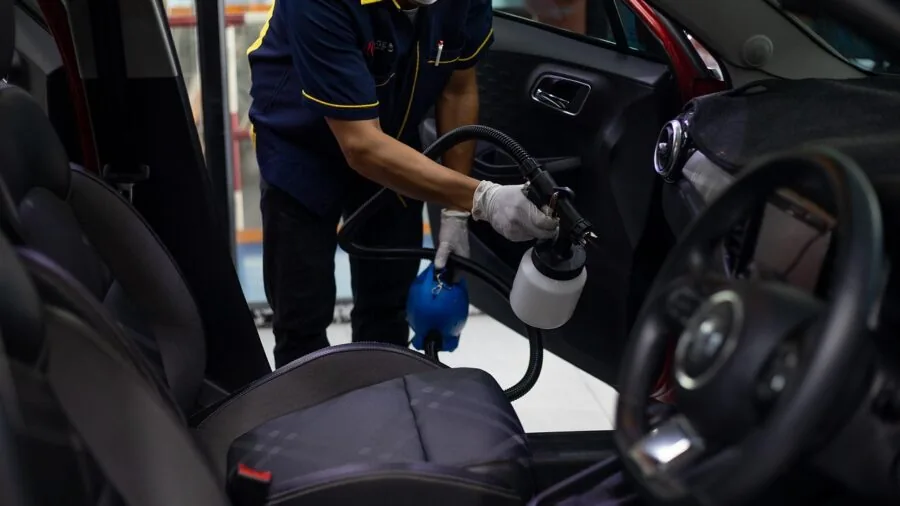 Parent cleaning and maintaining car seat fabric in vehicle interior