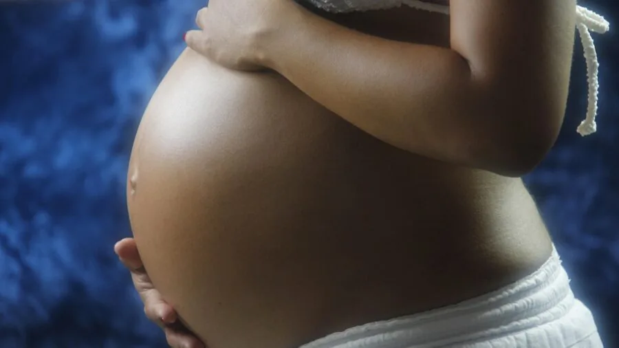 Parent cradling newborn infant in arms, showing bonding and safe baby holding techniques