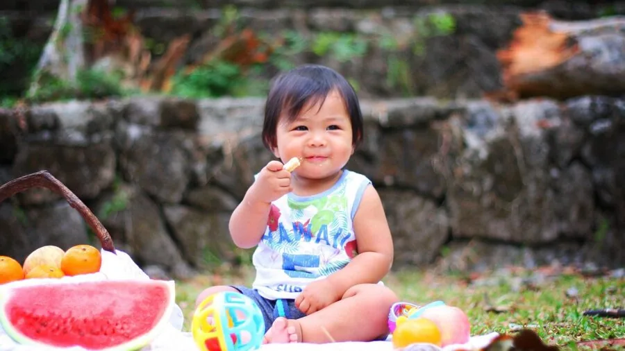 Parent feeding smiling baby nutritious food, emphasizing safe mealtime practices and child wellness