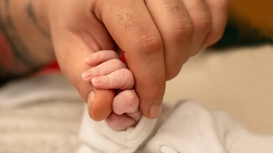 Parent gently applying lotion to baby's sensitive skin during skincare routine