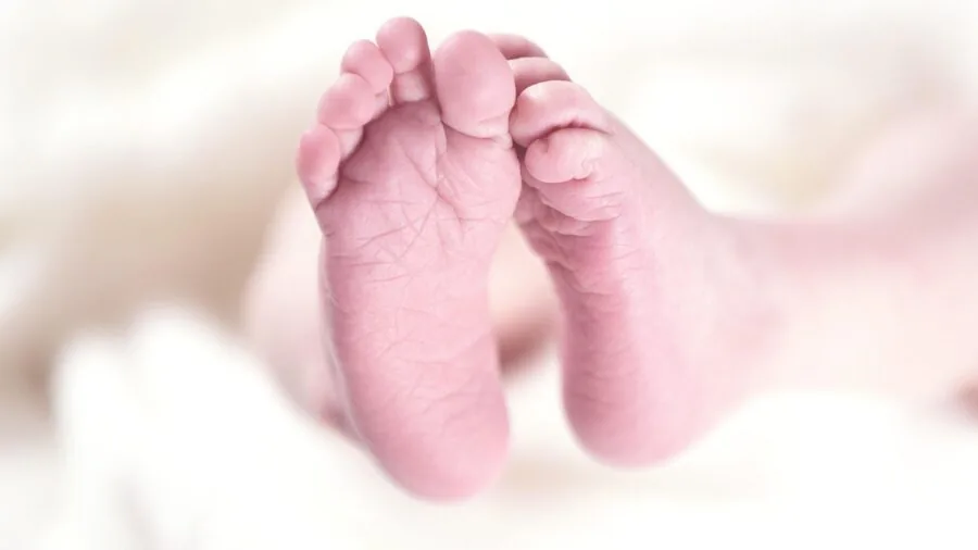 Parent gently applying lotion to newborn baby's delicate skin during care routine