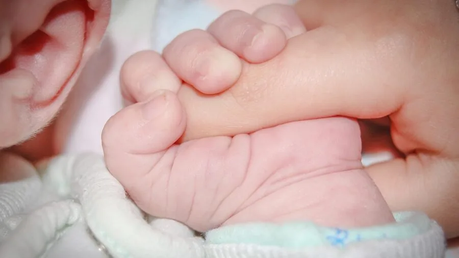 Parent gently examining baby's delicate skin during outdoor care routine