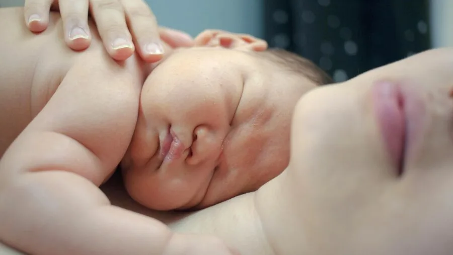 Parent monitoring baby remotely on smartphone from another room at night