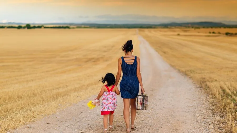 Parent navigating stroller on outdoor pathway with natural surroundings and movement