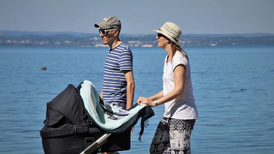 Parent running downhill with jogging stroller on outdoor trail during daytime exercise