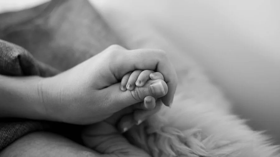 Parent safely holding baby bottle during feeding time with infant