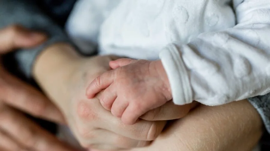 Parent thoughtfully selecting baby care items while organizing nursery supplies and making informed parenting decisions