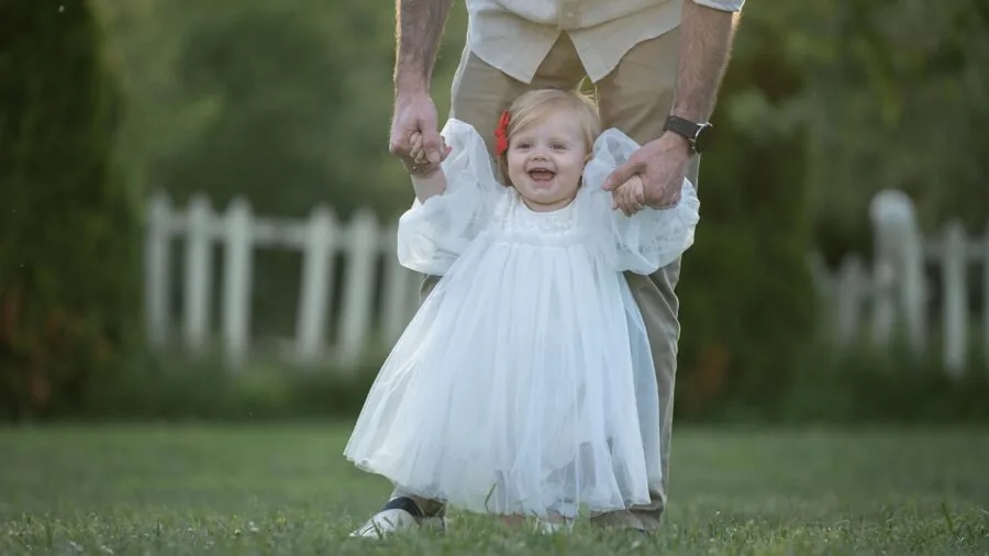 Parent walking with stroller in bright sunlight, demonstrating sun protection needs for outdoor baby care