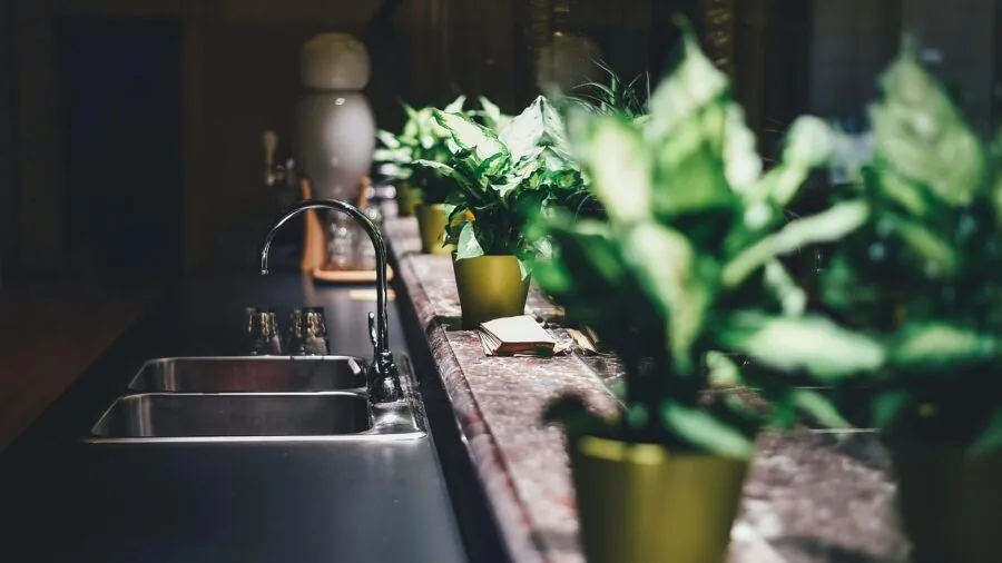 Parent washing dishes in kitchen sink during daily household cleaning routine